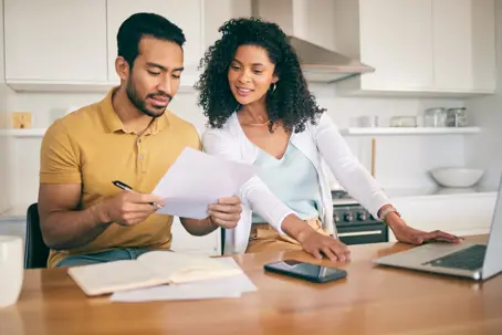 Couple, insurance paperwork and budget planning with laptop, bills and finance with taxes and mortgage. Financial documents, payment and loan with policy, audit and review with asset management stock photo
