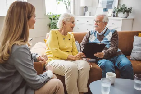 Mid adult female layer and senior couple going through will during a meeting in the living room.