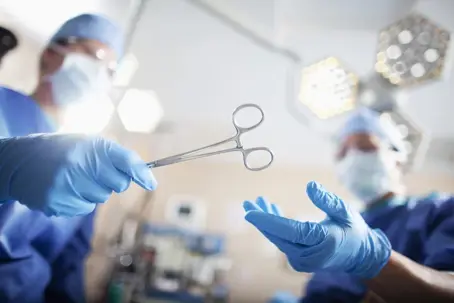 Low angle view of hands of doctor surgeon nurse passing medical equipment tool in surgery operating room hospital