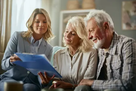 Mid adult female layer and senior couple going through will during a meeting in the living room.